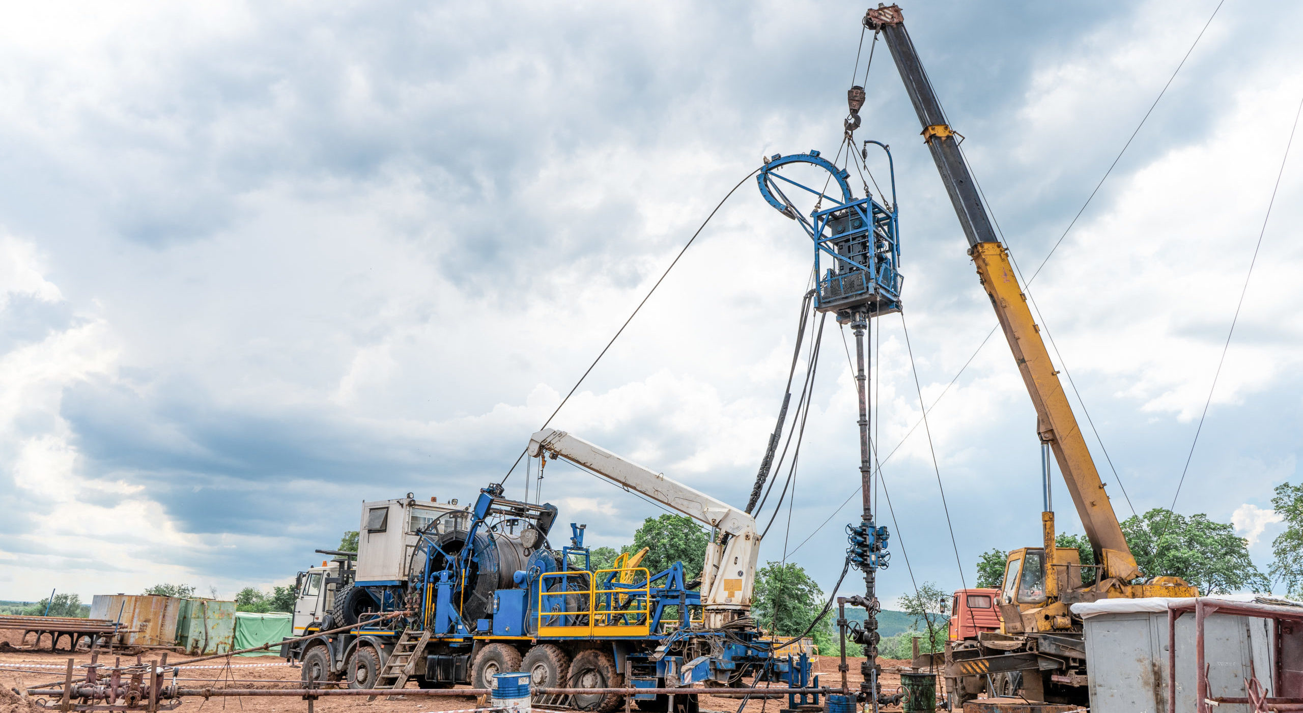 Coiled tubing unit doing well clean out. Wireline equipment hanging from top drive ready to be lowered downhole for logging